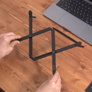 Person holding a black foldable stand.