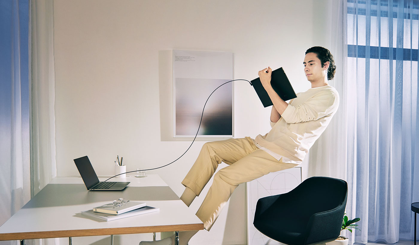 A man floating away from his desk, while in creative flow, using a Wacom Movink tablet