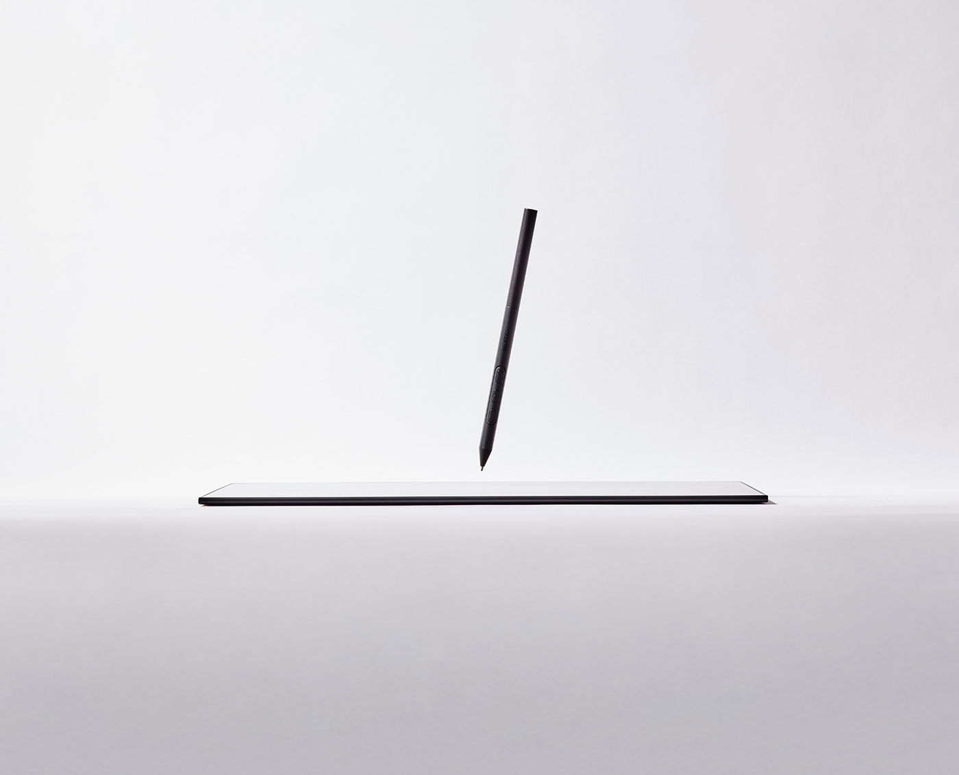 A sleek stylus elegantly rests upon a white tablet, ready for use