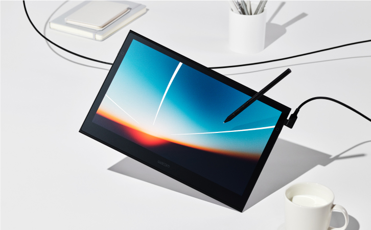 Wacom Movink featuring a vibrant image on its pen display. Tablet is levitating on white table with office supplies.